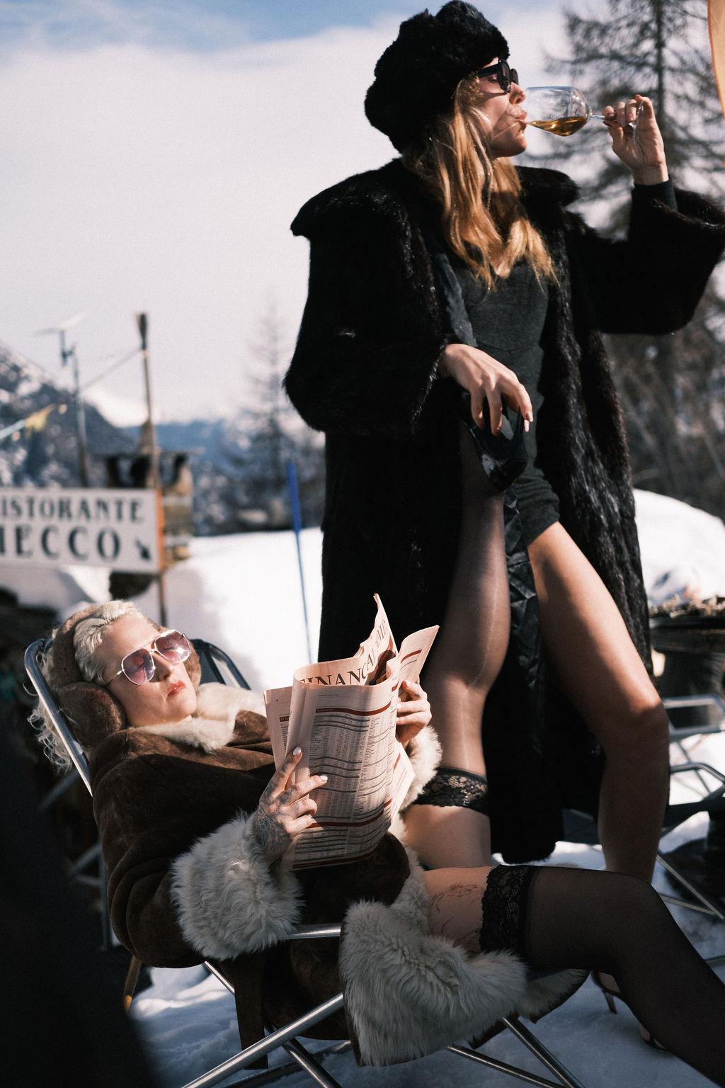 Valentina Dellagravis with a woman in furs in a snowy mountain setting, evoking luxury travel companionship.